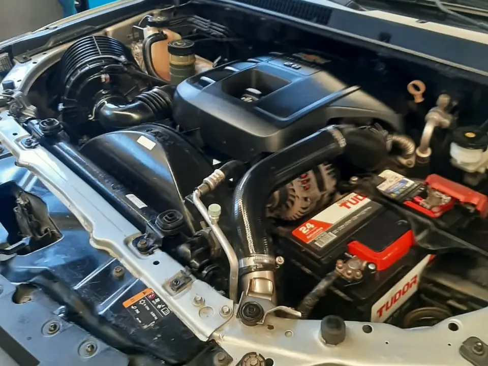 Compartimento do motor de uma picape a diesel com o capô aberto na oficina da GiroTech
